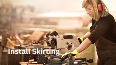Woman using a Mitre Saw to install Skirting